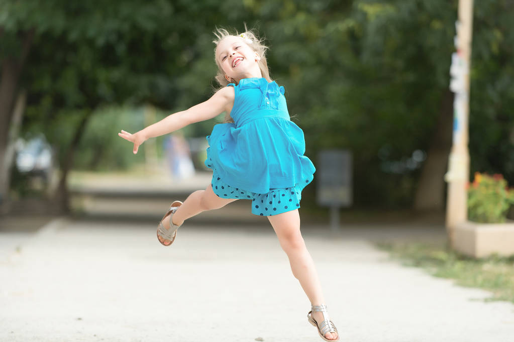 小さな赤ちゃんの笑顔青いドレスのジャンプ - 写真・画像
