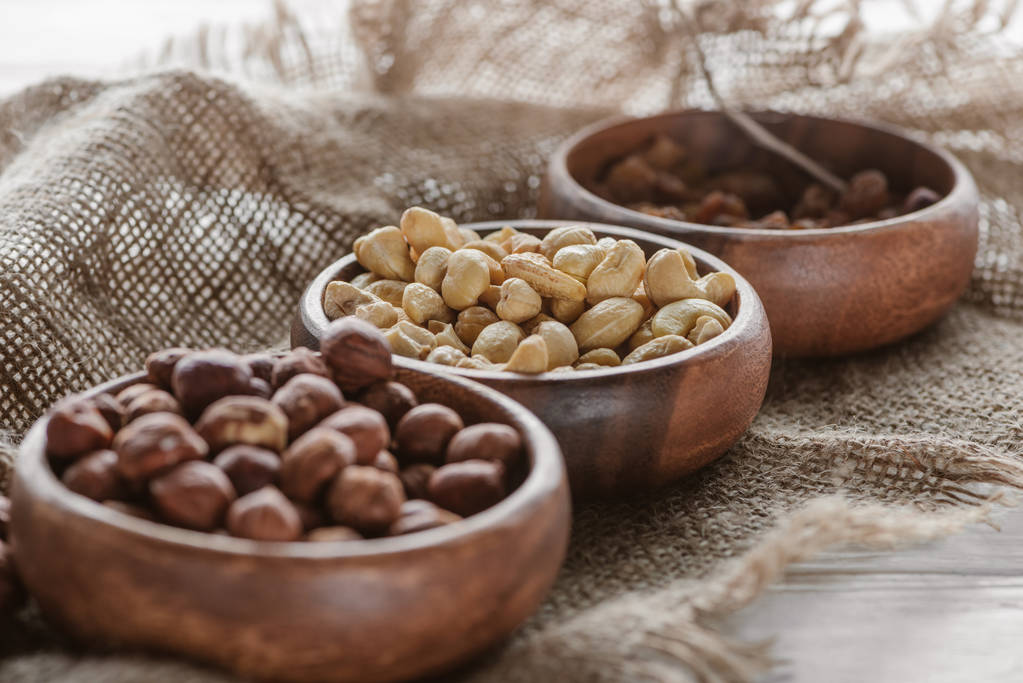 mix of nuts in wooden bowls on sackcloth - Photo, Image