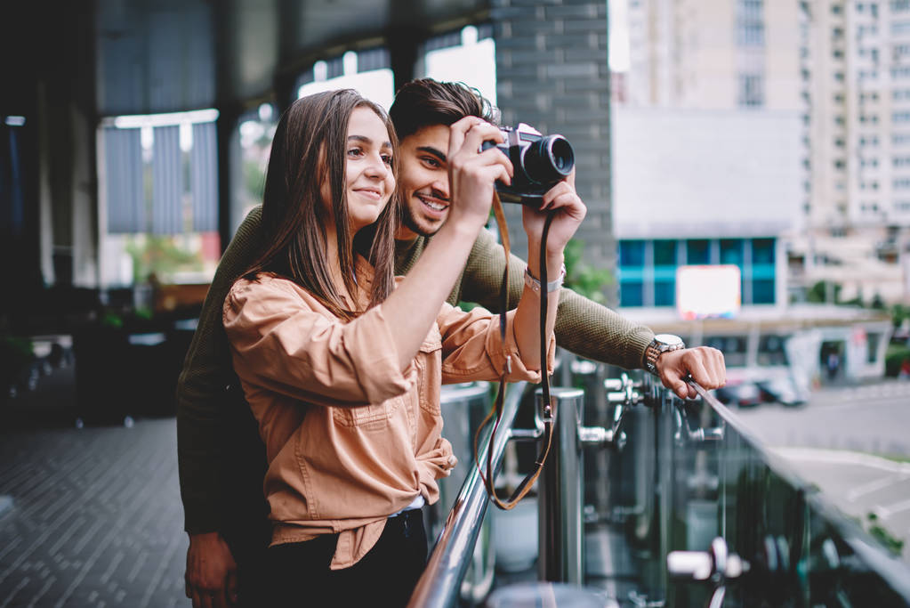 männliche und weibliche Hipster-Paar, das Zeit miteinander verbringt, Fotos von der Stadt in der Freizeit zu machen, schöner Kerl, der seiner Freundin beibringt, Fotos auf Vintage-Kamera zu machen und Spaß an romantischen Dates hat - Foto, Bild