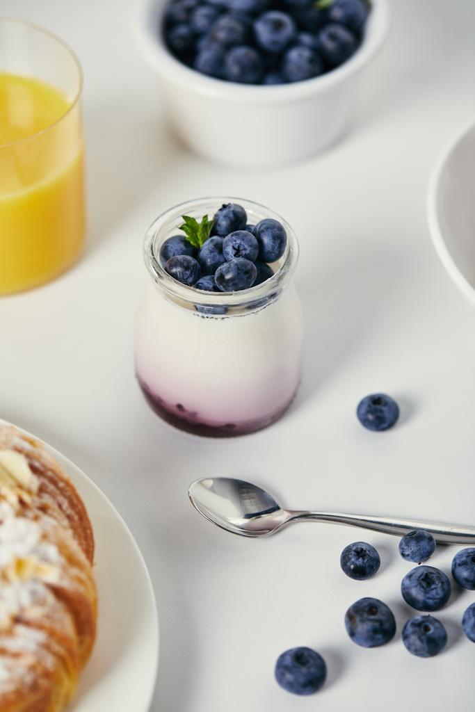 beyaz masa üstü günü kahvaltıda taze yaban mersini ile sağlıklı yoğurt görünümü kadar kapatın - Fotoğraf, Görsel