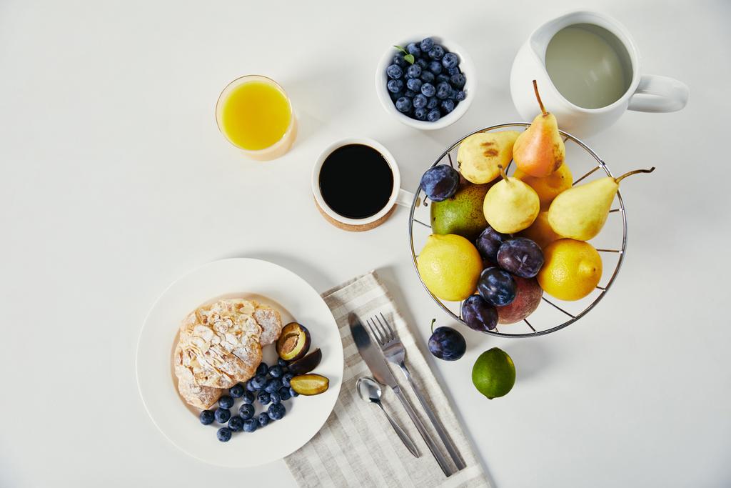 felülnézet, croissant, kávé csésze és pohár gyümölcslé reggeli, fehér felületre - Fotó, kép