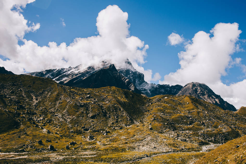 Vue avec de superbes montagnes himalayennes couvertes d'herbe jaune-verte, de hautes montagnes à l'horizon, un ciel bleu avec des nuages au Népal. Paysage montagneux. Voyage en Himalaya. Chemin vers le camp de base Everest
. - Photo, image