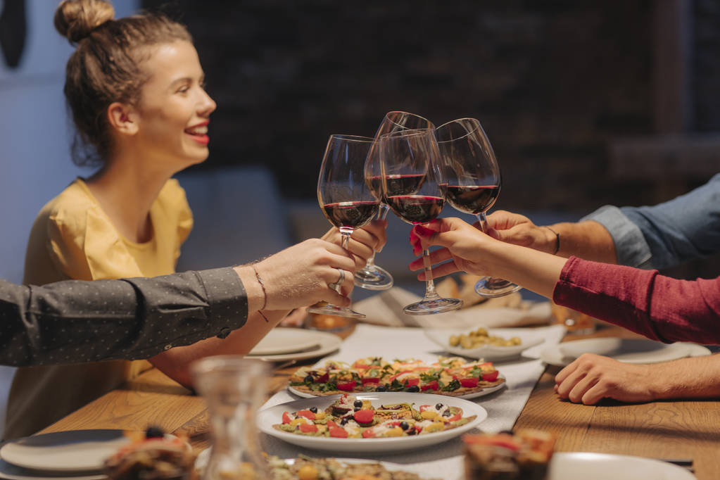 Группа друзей тост за бокалы вина на домашнем празднике
. - Фото, изображение