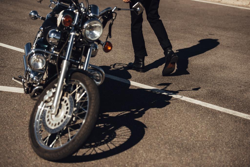 vista ritagliata del motociclista maschio che va vicino alla classica moto chopper
 - Foto, immagini
