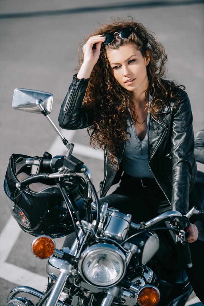 hermosa mujer sentada en motocicleta con casco
   - Foto, imagen