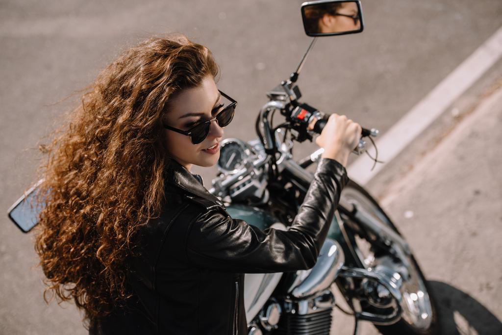 beautiful girl sitting on classical motorbike on parking - Photo, Image