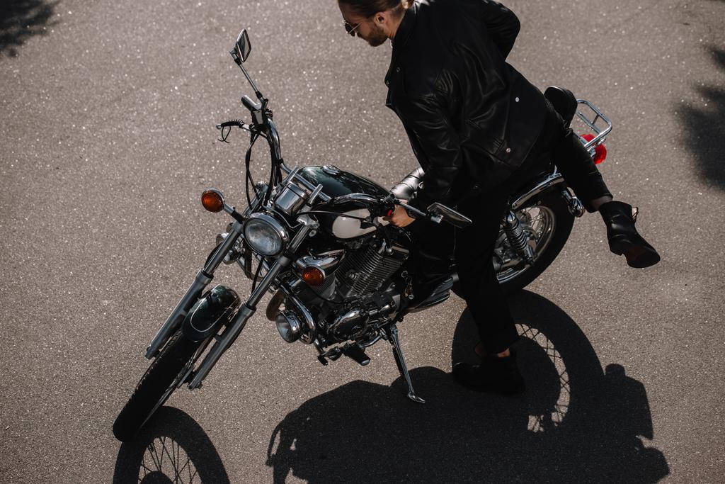 młody rowerzysta siedzi na vintage motocykl klasyczny na drodze - Zdjęcie, obraz