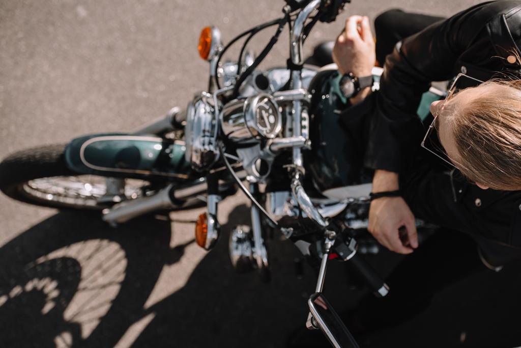 bovenaanzicht van biker zittend op vintage klassieke motorfiets - Foto, afbeelding