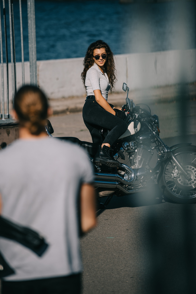 selective focus of man going to girl with classic motorcycle  - Photo, Image