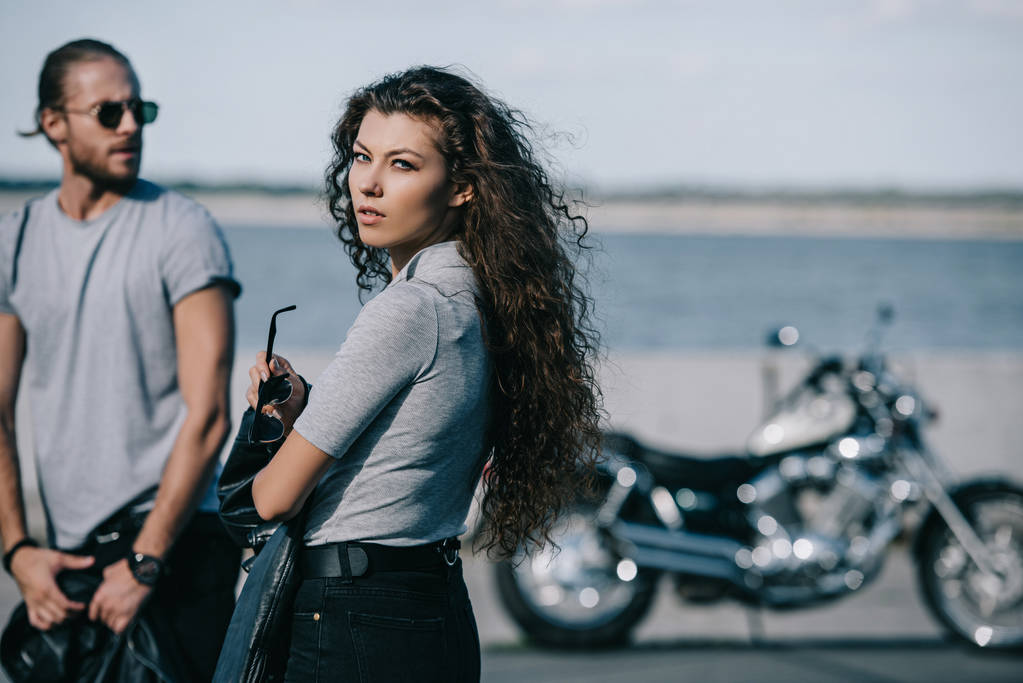 jovem casal de motociclistas com motocicleta vintage na cidade
 - Foto, Imagem
