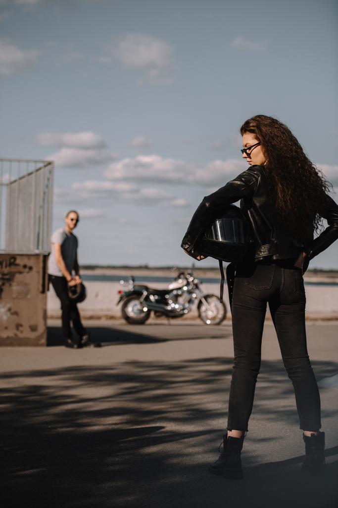 girl holding helmet and standing in front of boyfriend with motorbike  - Photo, Image