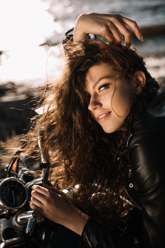 バイクの上に座って魅力的な巻き毛の少女 - 写真・画像