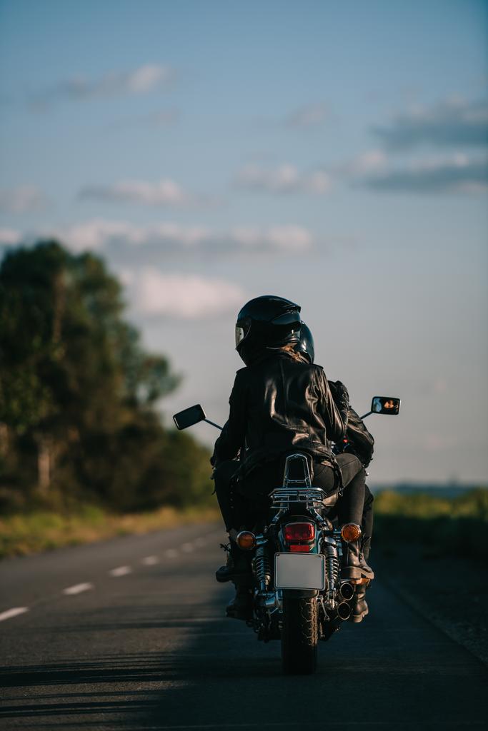 vista trasera de los ciclistas en cascos a caballo motocicleta en carretera del país
 - Foto, Imagen
