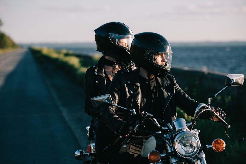 пара байкеров в шлемах на классическом мотоцикле по проселочной дороге
 - Фото, изображение