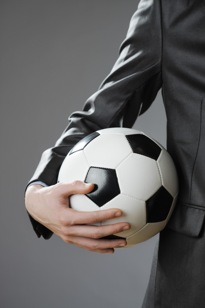 κομψό επιχειρηματίας που έχει μια μπάλα ποδοσφαίρου - Φωτογραφία, εικόνα