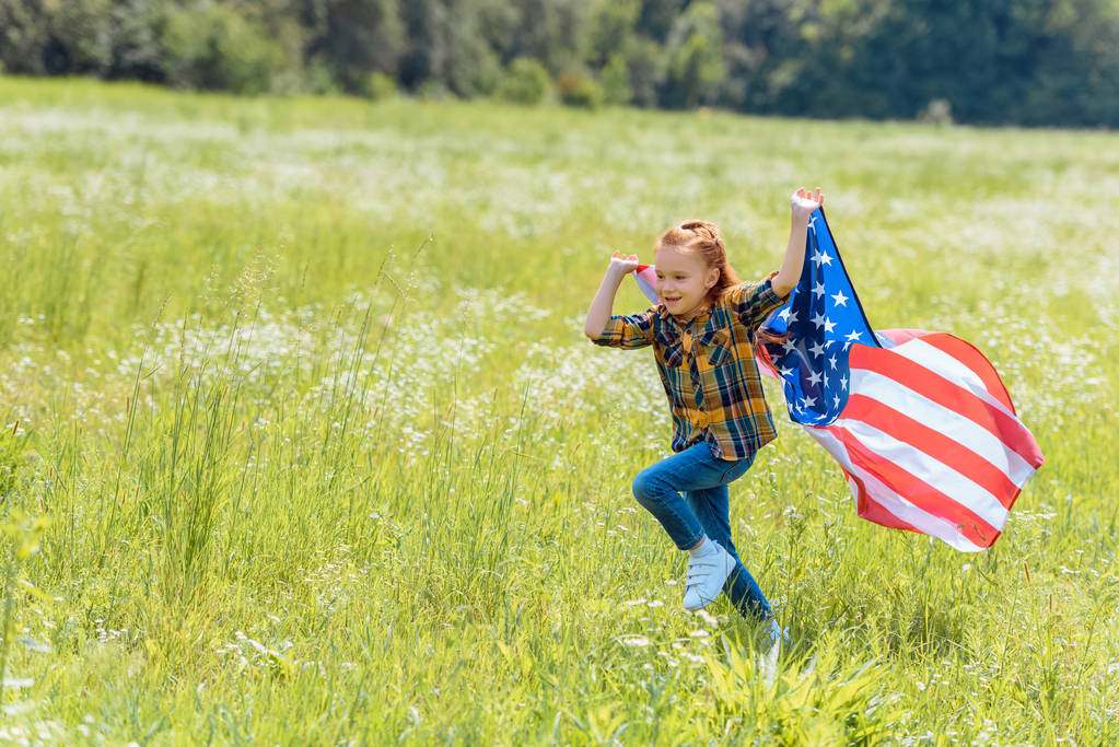 gyermek kezében amerikai zászló területen fut. - Fotó, kép