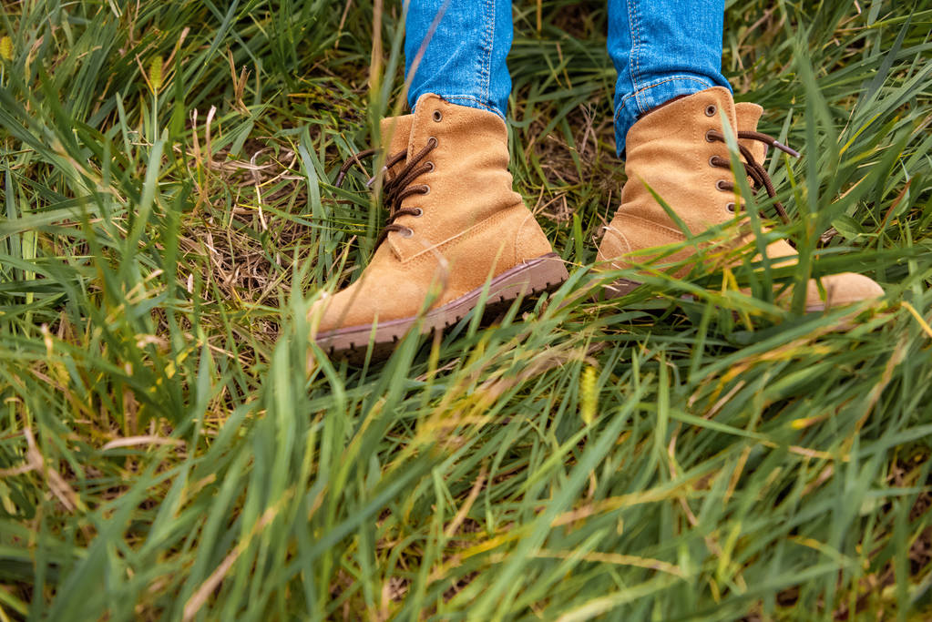 cropped shot of childish legs in boots on green grass - Photo, Image