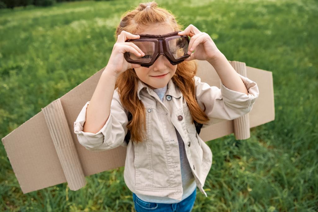 πορτρέτο του μικρού παιδιού στο πιλοτικό κοστούμι φοράει προστατευτικά γυαλιά καλοκαίρι πεδίο - Φωτογραφία, εικόνα