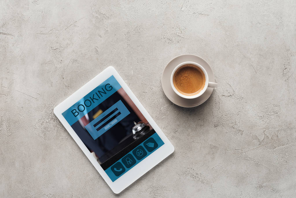 felülnézet, a kávé és a tablet app foglalás képernyőjén a betonfelület - Fotó, kép