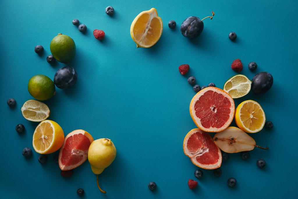 vista superior de frutas maduras orgânicas e bagas na superfície azul
 - Foto, Imagem