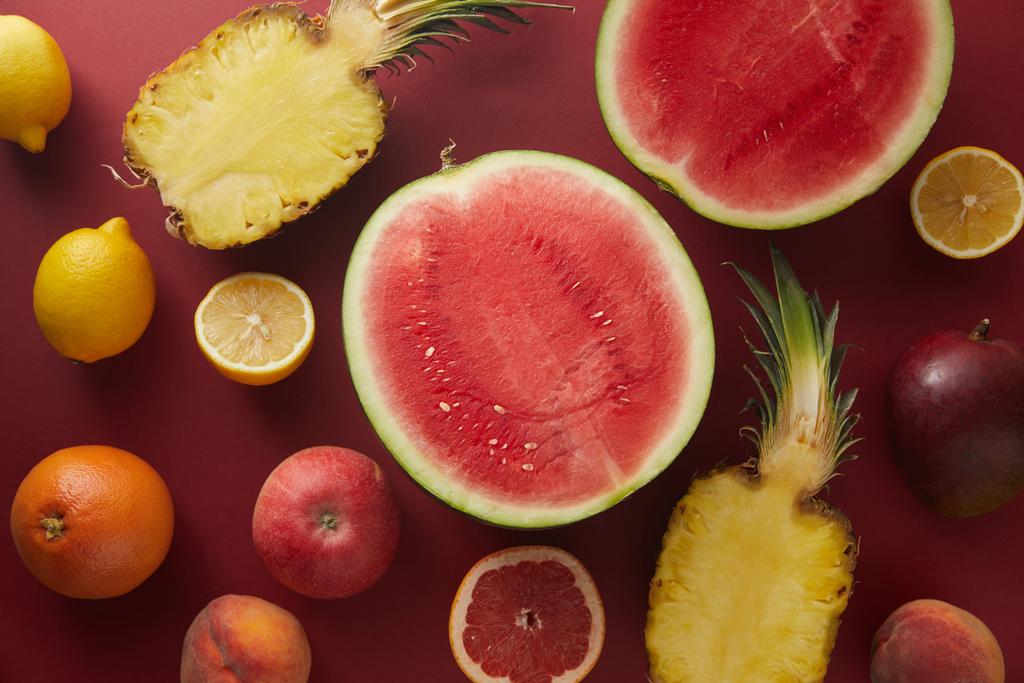kohonnut näkymä leikata vesimeloni ja ananas punaisella pinnalla
 - Valokuva, kuva