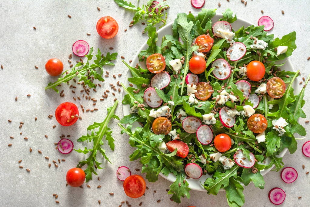 Čerstvý salát s rukolou a zeleniny na talíři, pohled shora - Fotografie, Obrázek