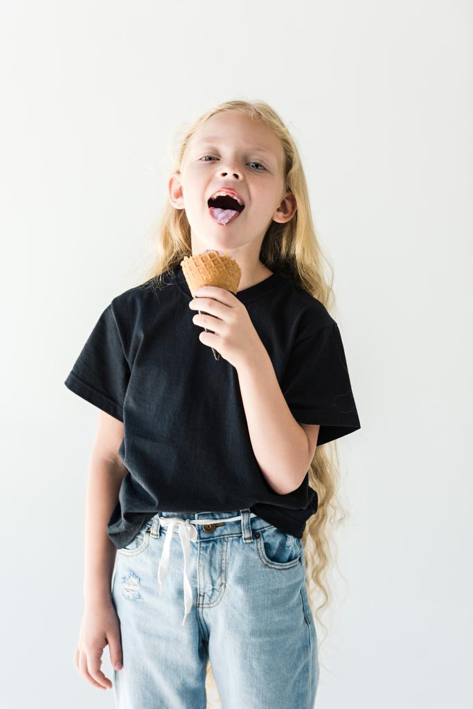adorable happy child with long curly hair eating ice cream and smiling at camera isolated on white - Photo, Image