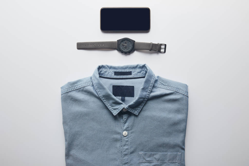 vista superior de la camisa, smartphone y reloj de pulsera aislado en blanco
 - Foto, Imagen