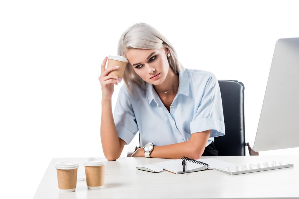 portrait of tired businesswoman at workplace with disposable cups of coffee, notebook and computer screen isolated on white - Photo, Image