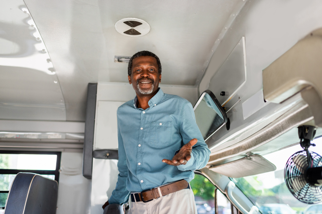 otobüs içinde ayakta ve kameraya bakarak mutlu olgun Afro-Amerikan otobüs şoförü - Fotoğraf, Görsel