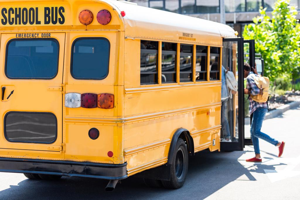 estudiantes caminando en el autobús escolar en el estacionamiento
 - Foto, imagen
