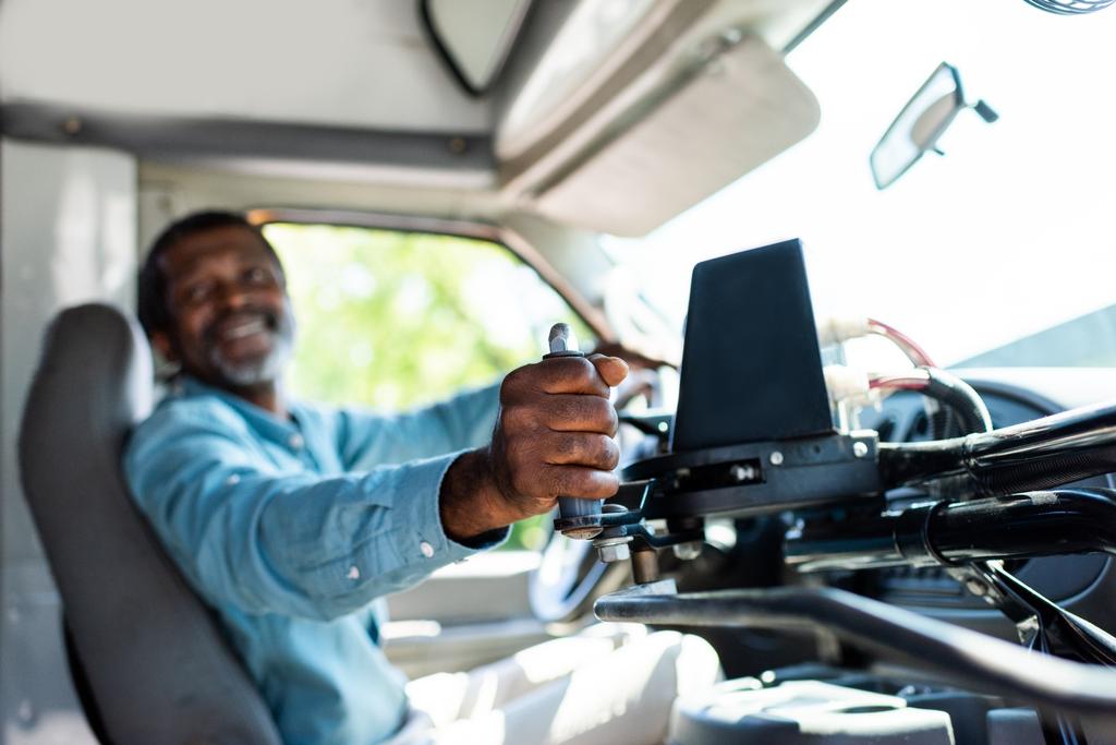 volwassen Afrikaanse Amerikaanse buschauffeur trekken hendel op bus - Foto, afbeelding