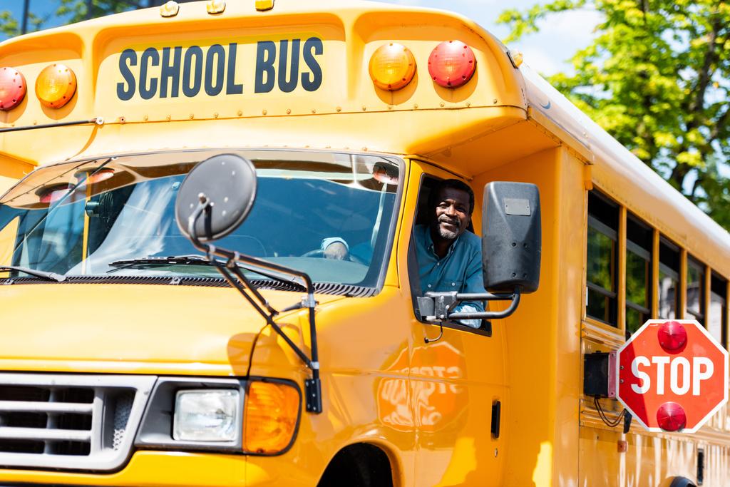 motorista de ônibus escolar sênior bonito olhando para a câmera através da janela
 - Foto, Imagem