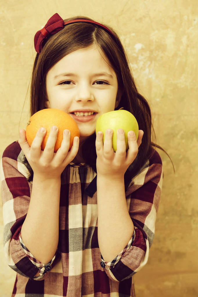 Sevimli kız portakal ve elma elinde tutan - Fotoğraf, Görsel