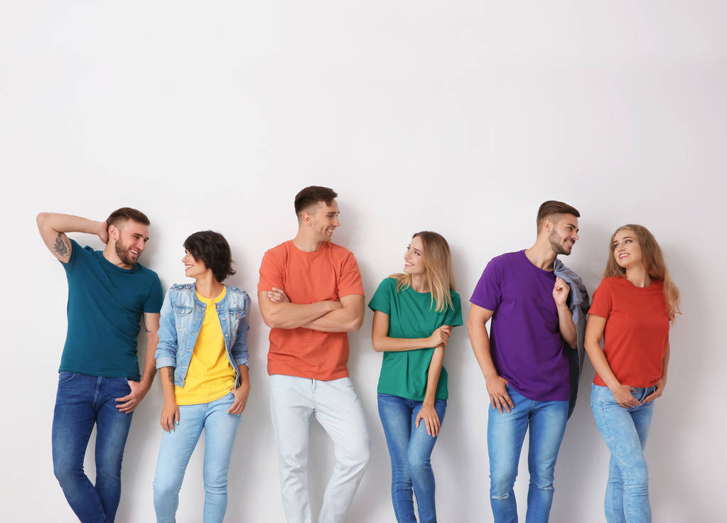 Group of young people in jeans and colorful t-shirts on light background - Photo, Image