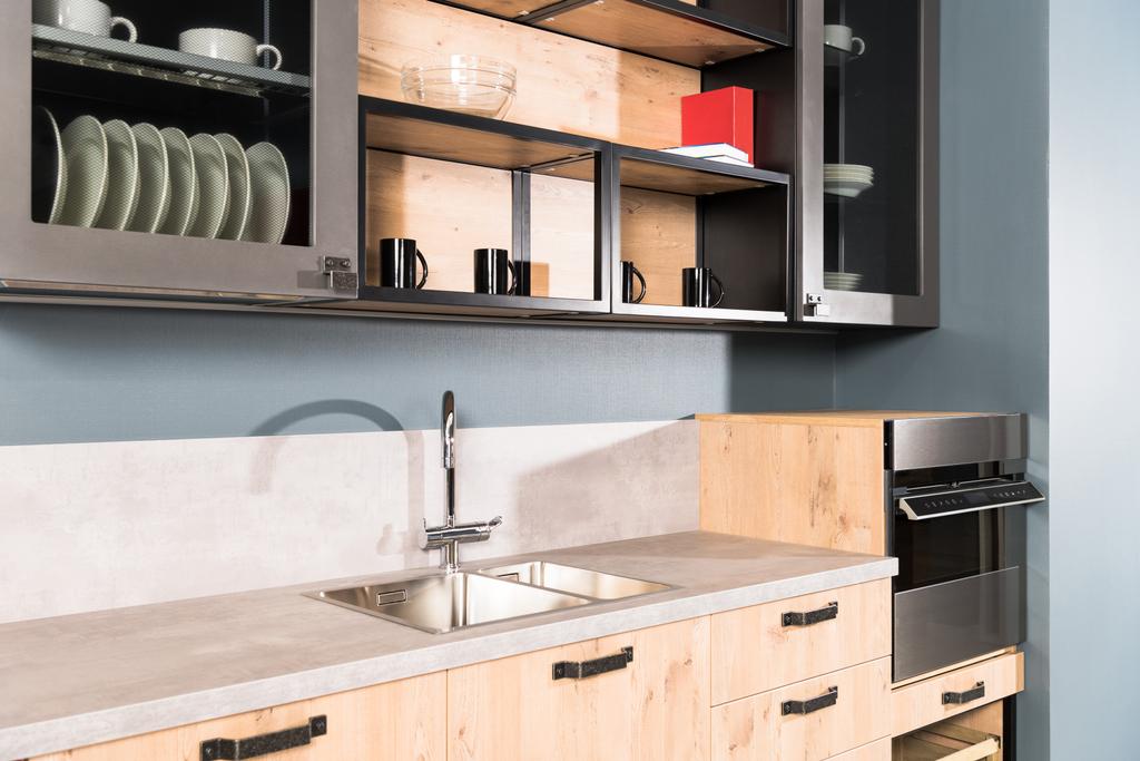 deel van moderne schone lichte keuken met spoelbak, kraan en planken met platen - Foto, afbeelding