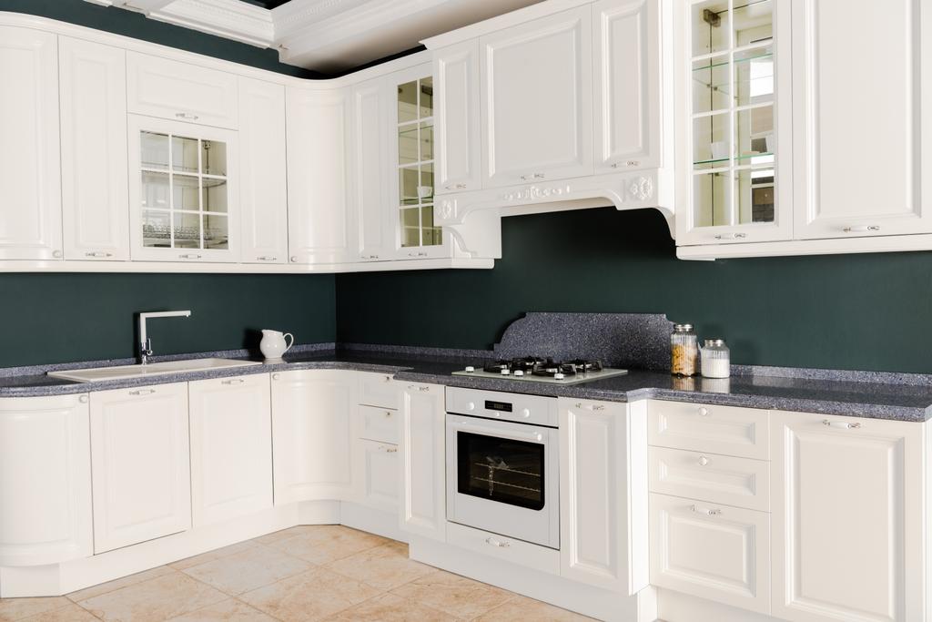 εσωτερικό του μοντέρνα ελαφριά κουζίνα με λευκά ξύλινα έπιπλα, εστίες μαγειρέματος και φούρνο - Φωτογραφία, εικόνα