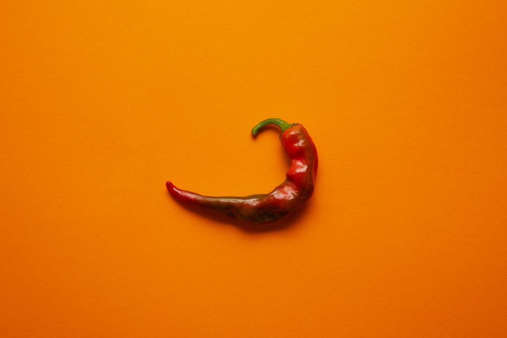felülnézete egyetlen red hot chili paprika narancssárga háttér - Fotó, kép