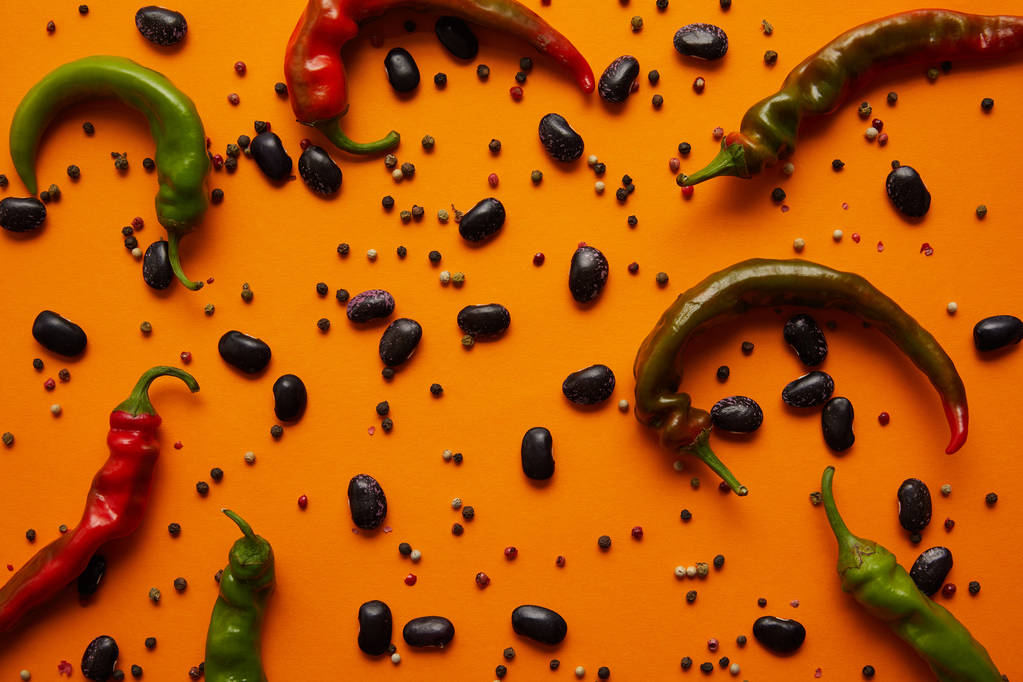 вид сверху на перец чили, фасоль харикос и перец на оранжевом фоне
 - Фото, изображение