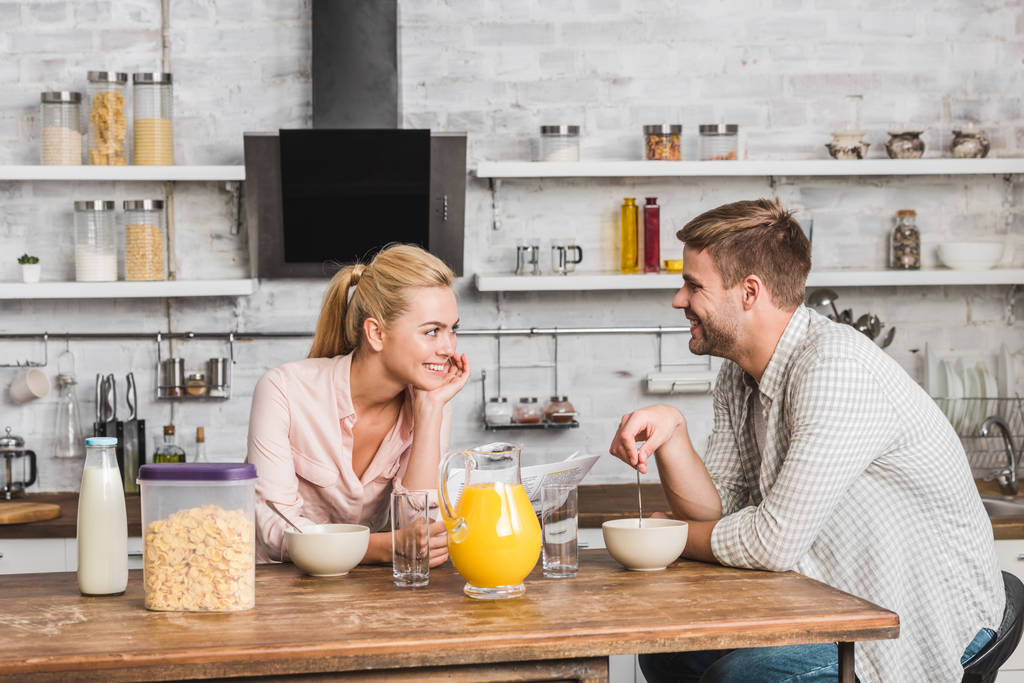 casal tomando café da manhã na cozinha, namorada segurando jornal
 - Foto, Imagem