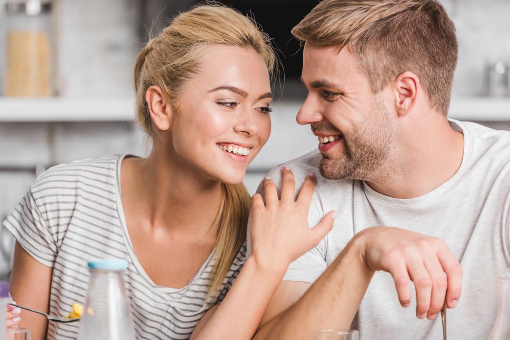 coppia sorridente che si abbraccia durante la colazione in cucina
 - Foto, immagini