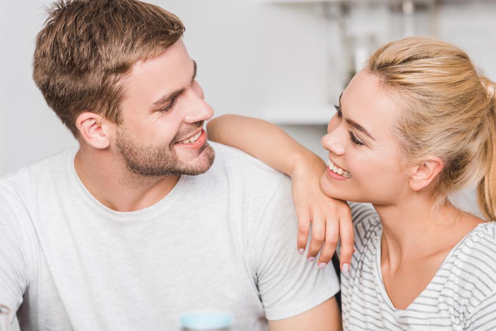 Porträt eines glücklichen Paares, das sich in der Küche anschaut - Foto, Bild