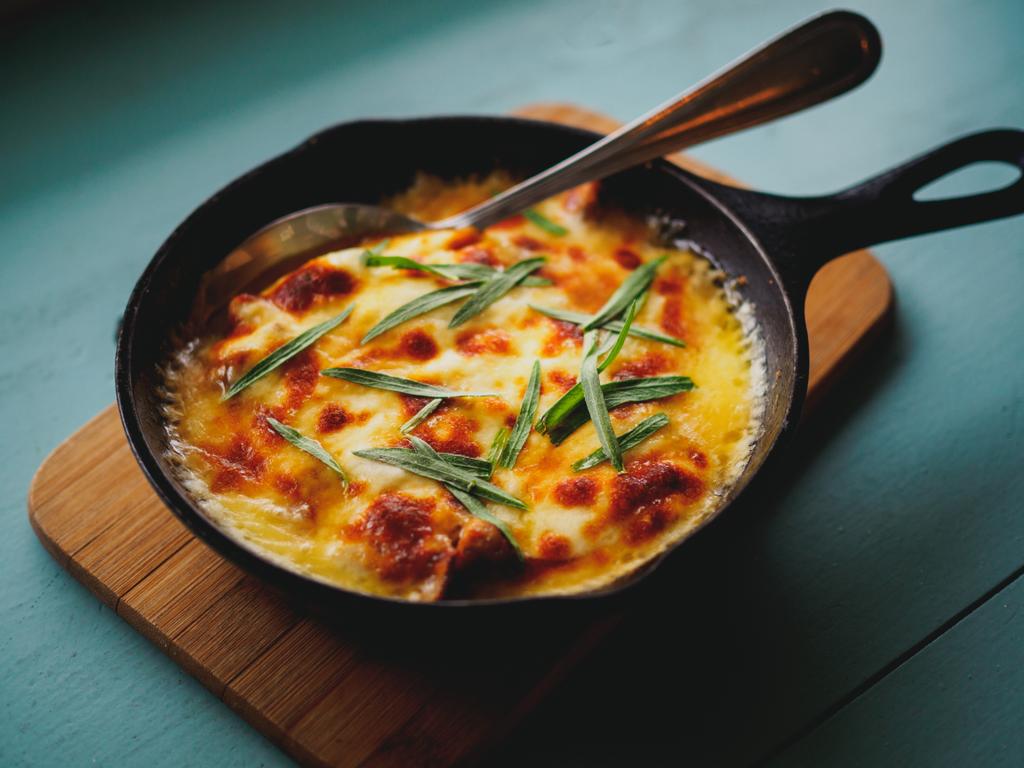 close up of homemade casserole with eggs and herbs in frying pan - Photo, Image