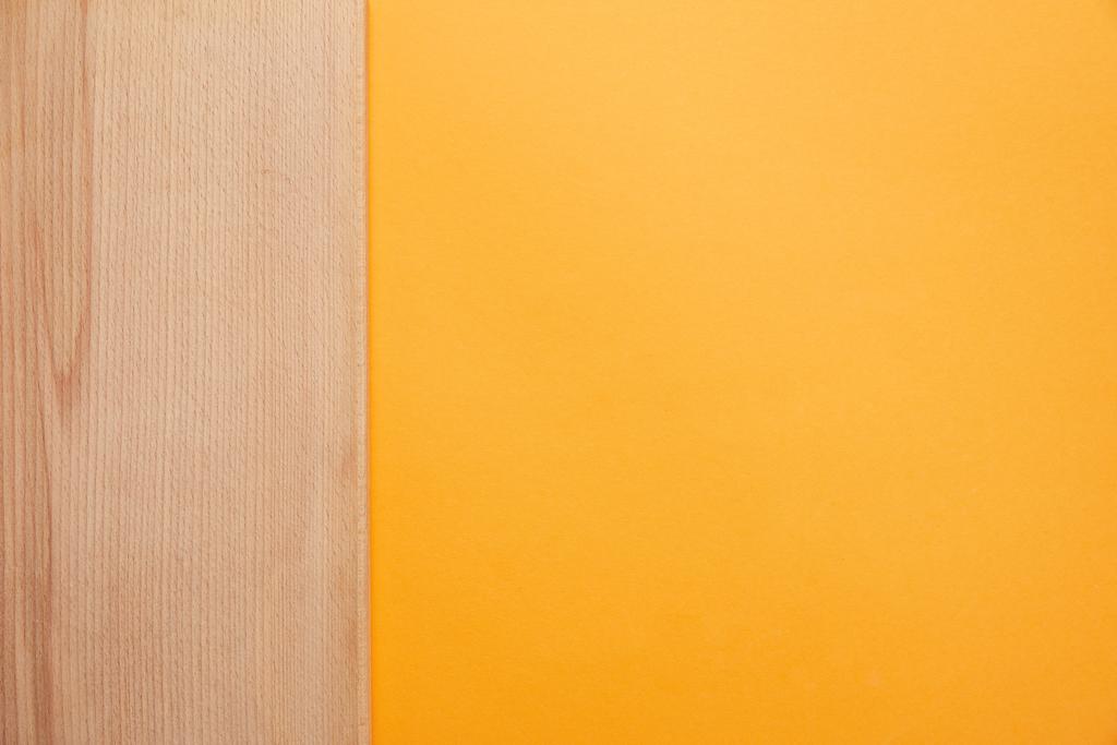 bovenaanzicht van helder oranje achtergrond en houten oppervlak - Foto, afbeelding