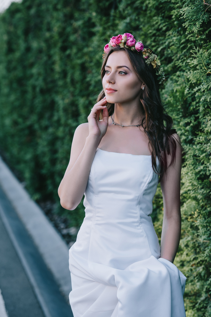 エレガントな花嫁ポーズ伝統的な白いウェディング ドレスし、花の花輪 - 写真・画像