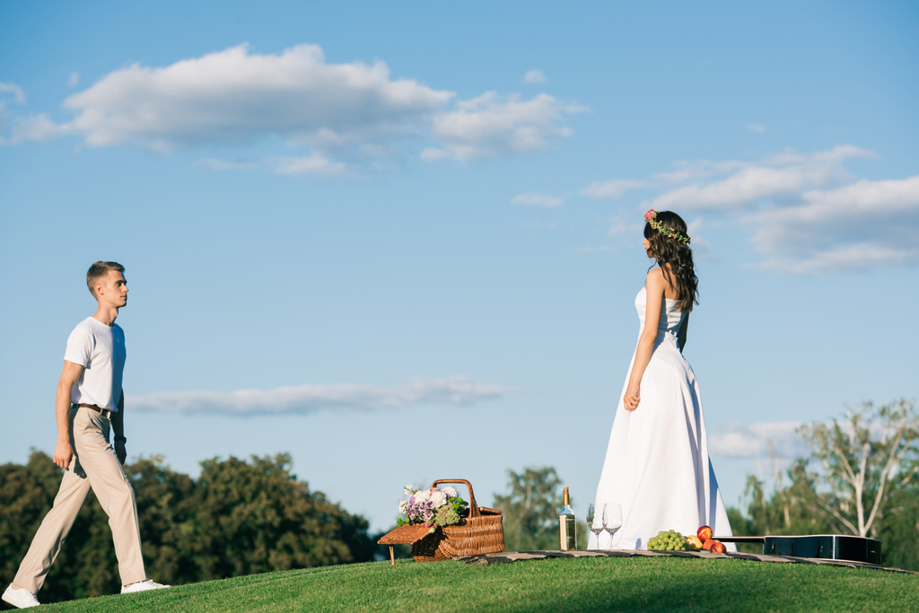 groom going to bride in white wedding dress on picnic - Photo, Image