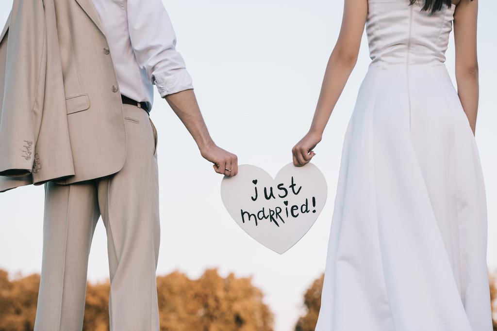 ジャストマリッジ碑文と心を持って若い結婚式のカップルのショットをトリミング  - 写真・画像