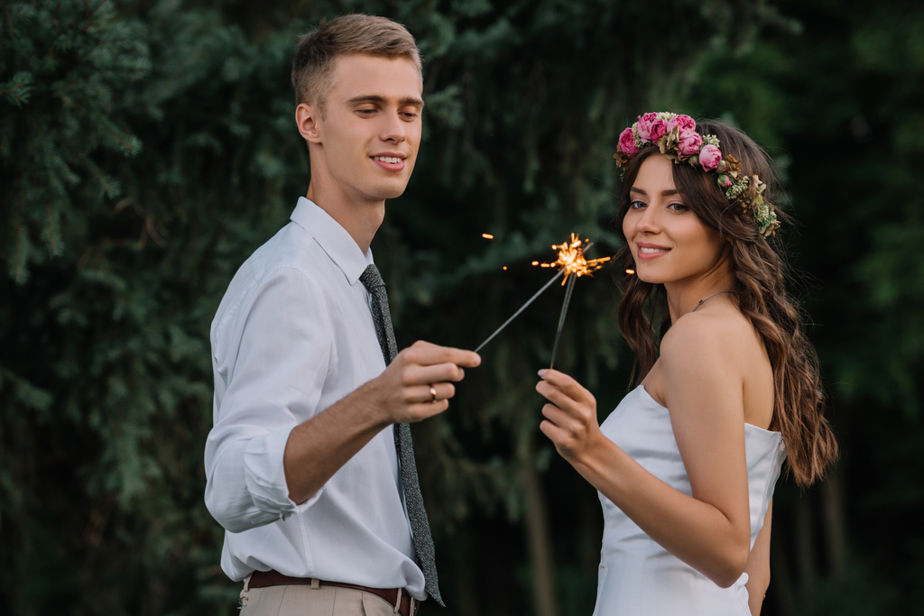 belo casamento feliz jovem casal segurando sparklers ao ar livre
 - Foto, Imagem