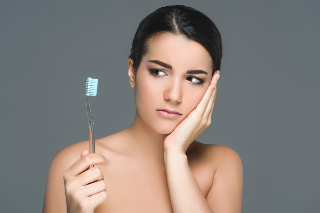 portrait of brunette woman with tooth brush having tooth ache isolated on grey - Photo, Image