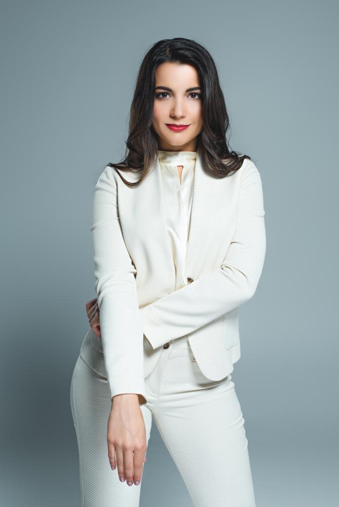 young stylish woman posing in white suit, isolated on grey  - Photo, Image